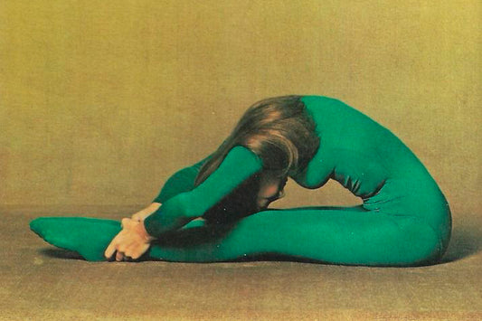 woman in a green unitard stretching on the floor