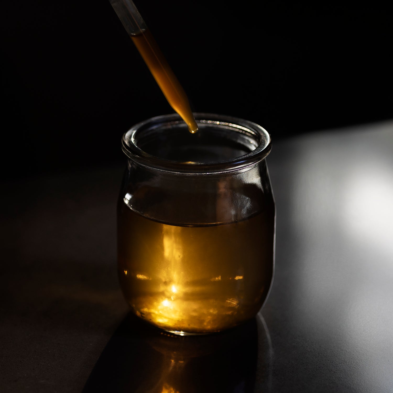 A pipette dropping tincture into a glass vessel